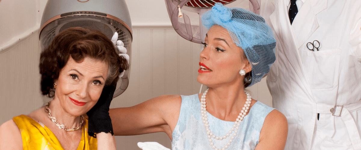 Två välsminkade kvinnor iklädda vintage på en retro-frisörsalong.