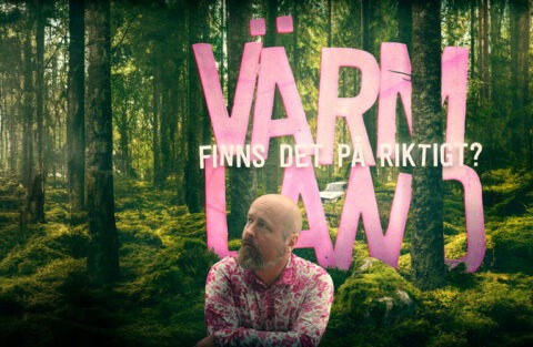 Erik sitter i skogen i en rosa skjorta med stora rosa bokstäver mellan träden.